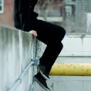 A person sitting on a concrete ledge.
