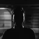 An upclose photo of a man but his face cannot be seen because of a shadow.