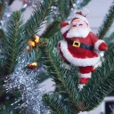 Santa Claus ornament hanging of tree.