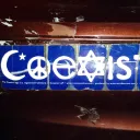 A coexist sticker on the bumper of a car.
