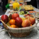 food on a table with a basket of fruit in the foreground
