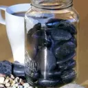 a jar filled with stones and a cup of coffee
