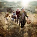 A multi generation family walking in a field.