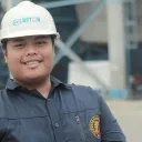 a man wearing a hard hat standing in front of a construction site