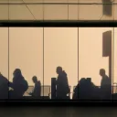 People walking creating shadows on building walls.