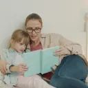 a woman reading a book to a child