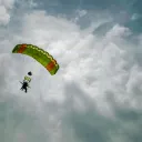 a man with a parachute in a sky filled with clouds