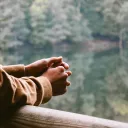 Hands clasped together overlooking a lake