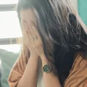 a woman sitting with her face in her hands