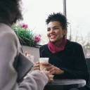two women seated at a table outdoors