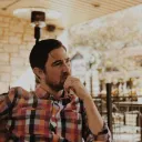 A man in deep thought while sitting outside.