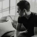A man sitting on a couch looking away.