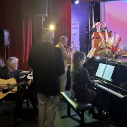 2024 Feast of Tabernacles Club Miléade La Gaillarde, France musicians gathered around the piano while a man leads songs