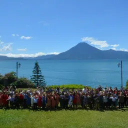 2024 Feast of Tabernacles Panajachel, Guatemala a large group of people outdoors with a body of water and mountain peak in the background