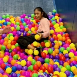 2024 Feast of Tabernacles Penang, Malaysia a girl sliding into a pile of colorful plastic bubbles
