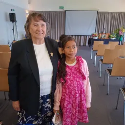 a woman and a girl standing indoors