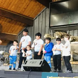 children on a stage with animals
