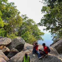 people seated on boulders outdoors