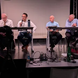 four men seated at tables