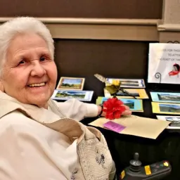 a woman seated at a table with greeting cards
