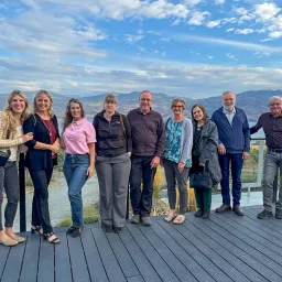 a group of people outside under a blue cloudy sky