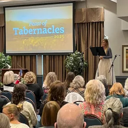 a group of people seated indoors listening to a music performance