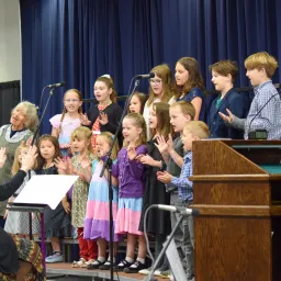 a children's choir singing on a stage