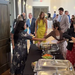 a line of people getting food from a table