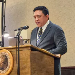 a man speaking at a lectern