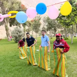 people participating in a sack race with balloons overhead