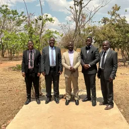 a group of men outdoors wearing suits