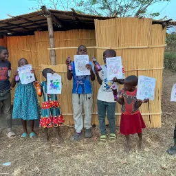 children holding up coloring pictures