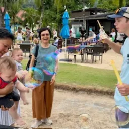 people standing outside and blowing bubbles