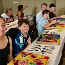 people seated at a table with their painting