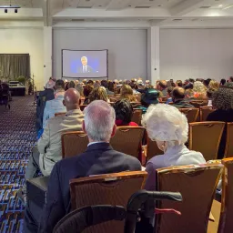 people seated in Church services watching a screen