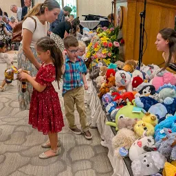 children selecting stuffed animals from a stage