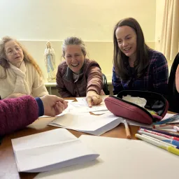 women smiling over a project on a table