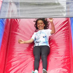 UYC British Isles a girl sliding on a red inflatable slide