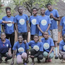 a group of children standing and sitting outside