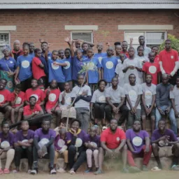 a large group of campers and staff outdoors in front of a building