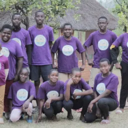 a group of children standing and sitting outdoors