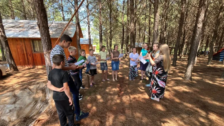2024 Feast of Tabernacles Gobernador Roca, Argentina a group of children standing in a semicircle outside and singing