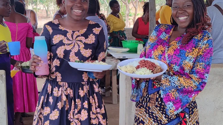 2024 Feast of Tabernacles Nkhwazi, Malawi two women holding plates of food while standing underneath a picnic shelter