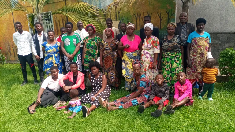 2024 Feast of Tabernacles Rwanda a group of people outside standing and sitting on the grass under palm trees