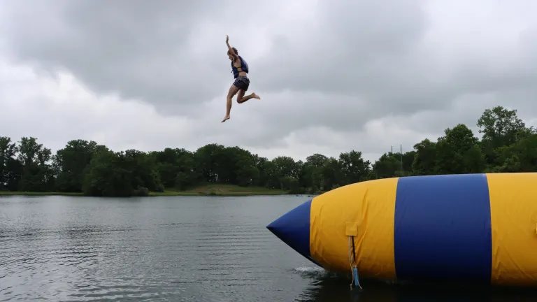 a person jumping into the water from an inflatable raft