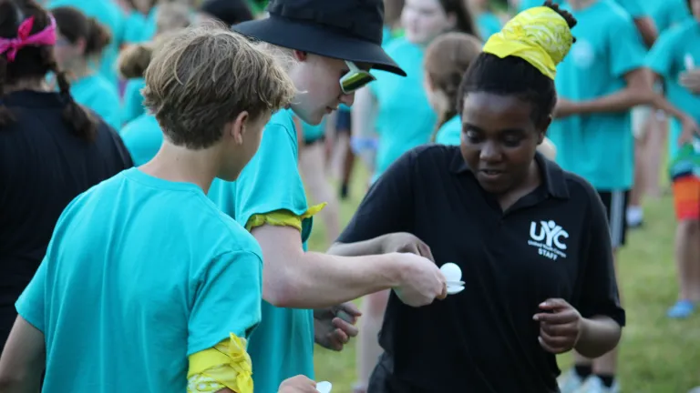two boys and a girl playing a game with a plastic spoon and egg