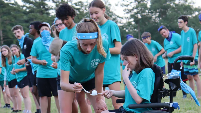 a group of teenagers wearing blue shirts and playing a game