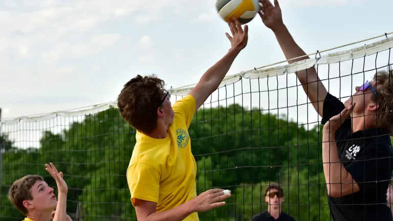teenage boys playing volleyball