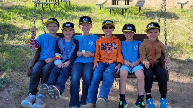 boys sitting on a swinging bench
