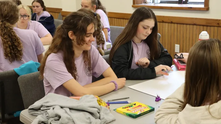 Campers at a table coloring in a page